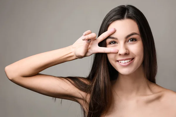 Retrato de mujer hermosa con piel sana sobre fondo gris — Foto de Stock