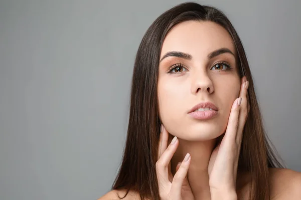 Portrait of beautiful woman with healthy skin on grey background — Stock Photo, Image