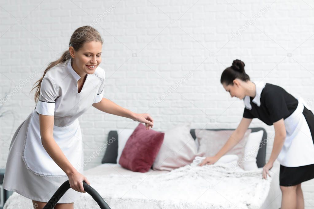 Beautiful female housekeepers working in room