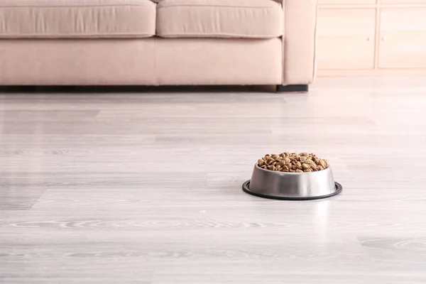 Bowl with dry pet food on floor — Stock Photo, Image