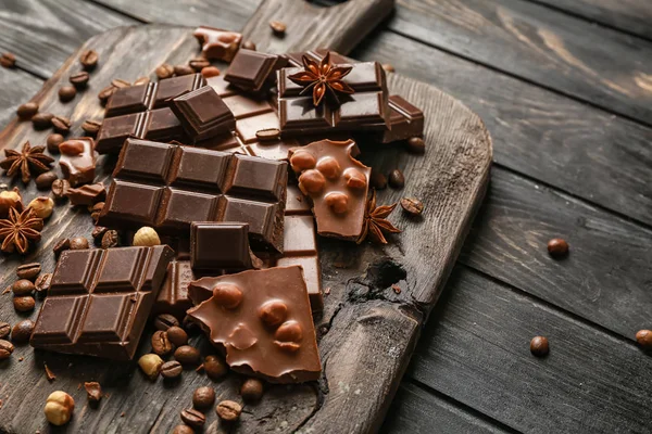 Sweet tasty chocolate on wooden board — Stock Photo, Image