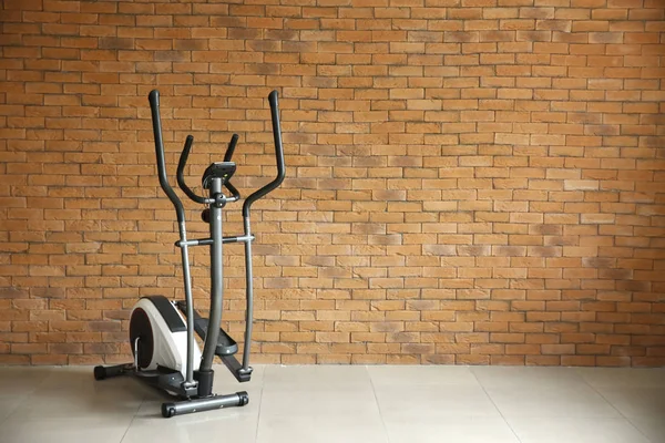 Máquina de exercício moderno perto da parede de tijolo — Fotografia de Stock