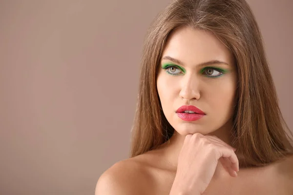 Красивая девушка с ярким макияжем на цветном фоне — стоковое фото