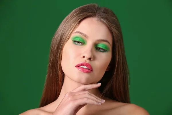 Krásná mladá žena s světlý make-up na barvu pozadí — Stock fotografie