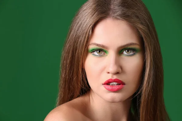 Hermosa mujer joven con maquillaje brillante en el fondo de color —  Fotos de Stock
