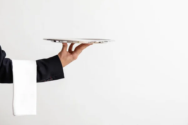 Hand of waiter with empty tray on light background — Stock Photo, Image