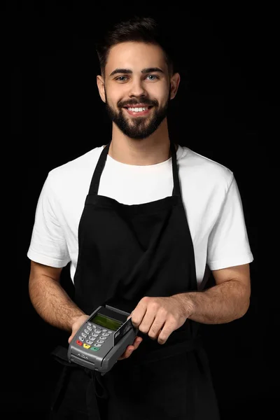 Gutaussehender Kellner mit Zahlungsterminal auf dunklem Hintergrund — Stockfoto
