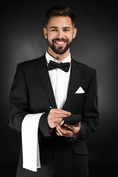 Handsome waiter with notebook on dark background — Stock Photo, Image