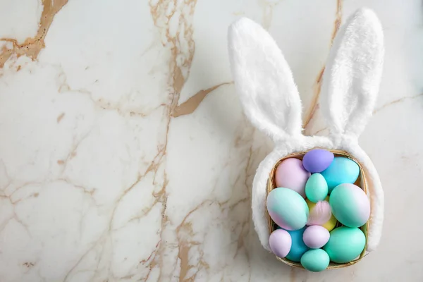 Hermosos huevos de Pascua y orejas de conejo sobre fondo claro — Foto de Stock