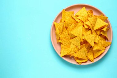 Renkli arkaplanda lezzetli nachos tabağı