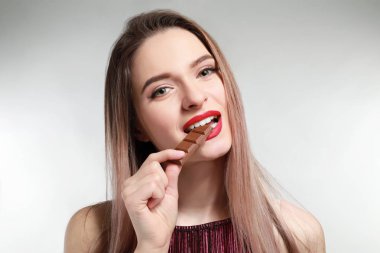 Yeme lezzetli çikolata üzerinde açık renkli güzel genç kadın