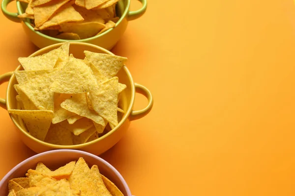 Macetas con sabrosos nachos sobre fondo de color — Foto de Stock