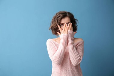 Güzel kadının yüzü onunla kapsayan portre renk arka plan üzerinde eller