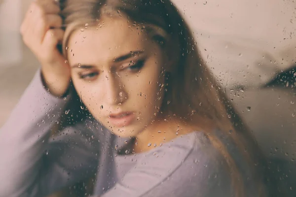 Einsame depressive Frau am Fenster zu Hause, Blick durch Glas — Stockfoto