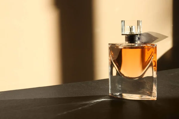Transparent bottle of perfume on dark table — Stock Photo, Image