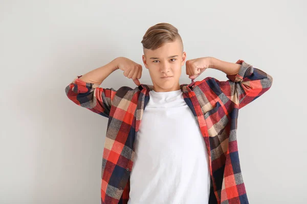 Adolescente ragazzo mostrando muscoli su sfondo bianco — Foto Stock