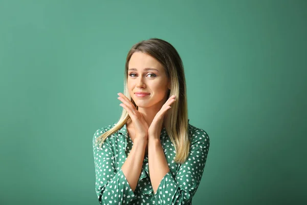 Sorrindo jovem mulher no fundo de cor — Fotografia de Stock