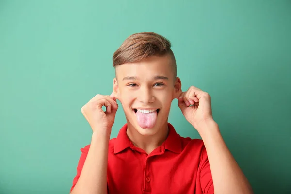Funny portrait of teenage boy on color background — Stock Photo, Image