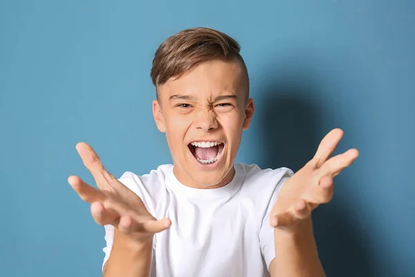 Rozzlobený dospívající chlapec na barevném pozadí — Stock fotografie