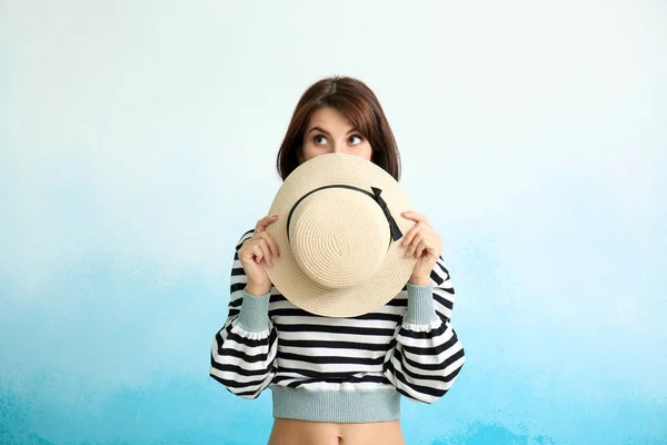Krásná žena, pokrývající obličej s kloboukem na barvu pozadí — Stock fotografie