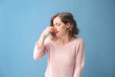 Burun renk arka plan üzerinde pinching güzel kadın portresi