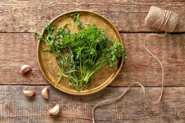 Taze otlar, sarımsak ve ahşap masa ipe metal tepsi