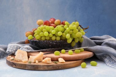 Olgun sulu üzüm ve ahşap kurullarında peynir ile plaka