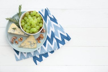 Olgun sulu üzüm ve Beyaz ahşap masa üzerinde peynir ile kase