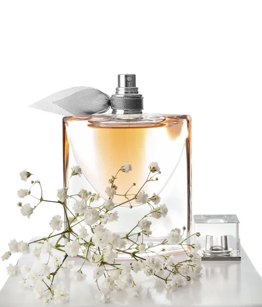 Doorzichtige fles parfum met bloemen op witte achtergrond — Stockfoto