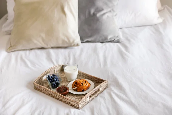 Tray with delicious breakfast on bed — Stock Photo, Image
