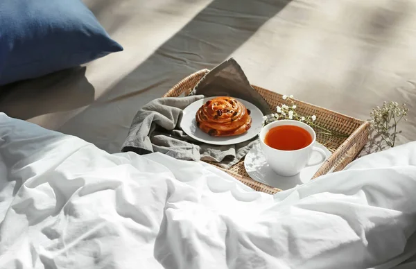 Wicker tray with delicious breakfast on bed — Stock Photo, Image