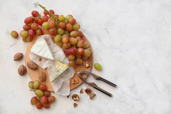 Érett lédús szőlő, sajt és dió a fény asztal — Stock Fotó