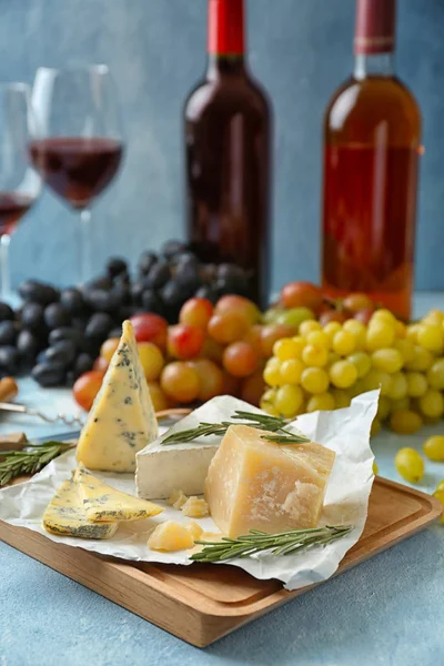 Различные сорта сыра с розмарином на деревянной доске — стоковое фото