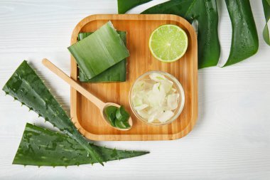 Aloe vera ve kireç beyaz masada ahşap tepsi