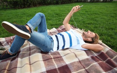 Yakışıklı genç adam Park müzik dinlemek