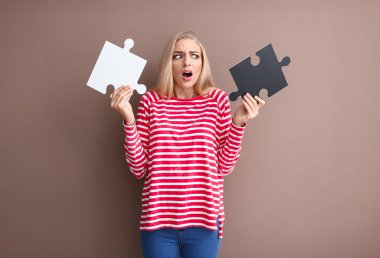 Renk arka plan üzerinde bulmacanın parçaları ile sorunlu genç kadın