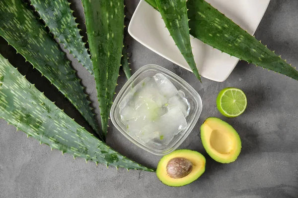 Bowl with peeled aloe vera and exotic fruits on grey table — Stock Photo, Image