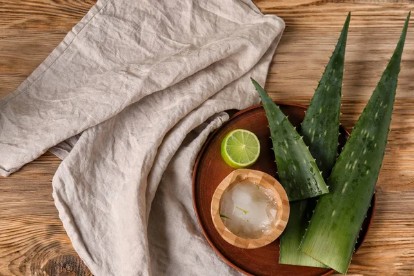 Plate with aloe vera and lime on wooden table — Stock Photo, Image