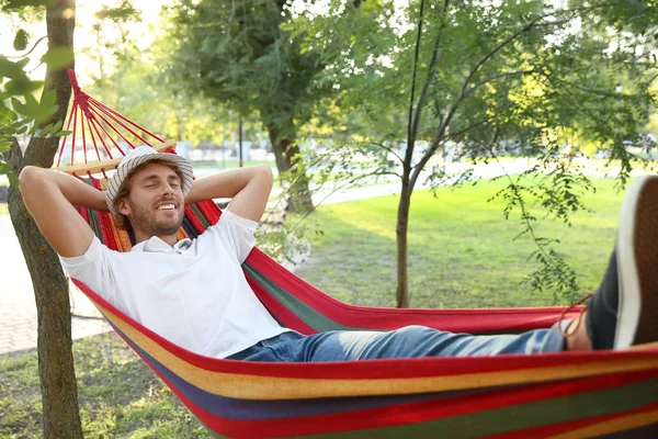 Handsome young man resting in hammock outdoors — Stock Photo, Image