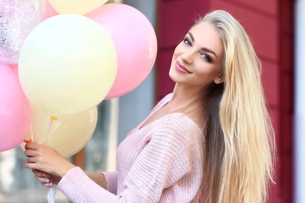 Schöne junge Frau mit Luftballons im Freien — Stockfoto