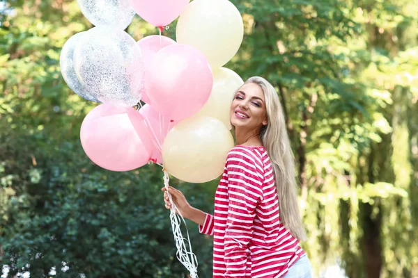 Schöne junge Frau mit Luftballons im Park — Stockfoto