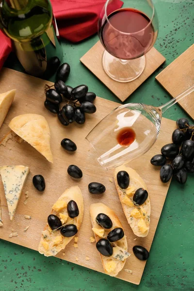 Tasty sandwiches with cheese, grapes and wine on color table — Stock Photo, Image