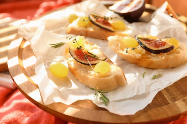 Tasty sandwiches with cheese, grape and fig on wooden board — Stock Photo, Image