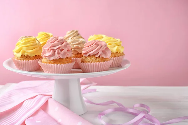 Stand com deliciosos cupcakes na mesa — Fotografia de Stock
