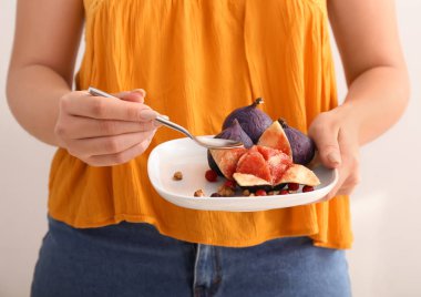 Kaşıkla, closeup taze olgun incir yiyen Kadın