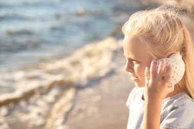 Deniz kabuğu Plajı ile sevimli küçük kız