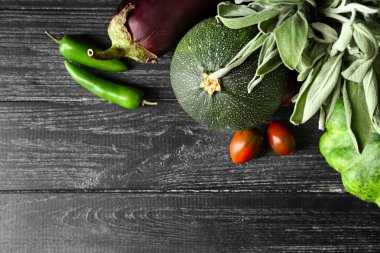 Ahşap masa üzerinde adaçayı yaprakları ile çeşitli taze sebze