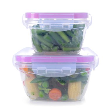 Beyaz arka planda donmuş sebzeli plastik kaplar.