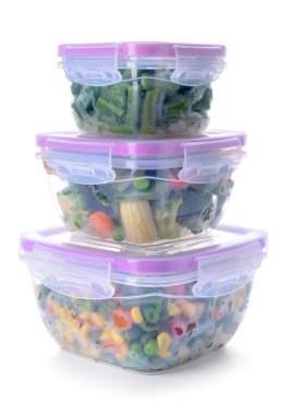 Beyaz arka planda donmuş sebzeli plastik kaplar.