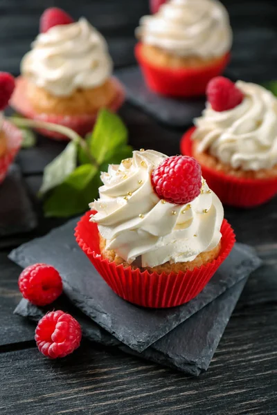 Delicious cupcakes with raspberries on wooden table — Stock Photo, Image
